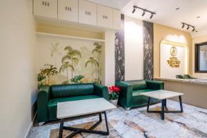 a lobby with two green couches and tables at Hotel Helixo Classic Kompally in Hyderabad
