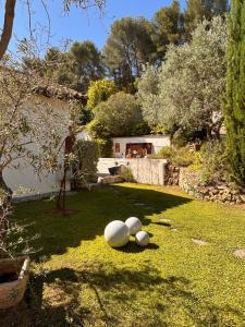 drie witte ballen liggen op het gras in een tuin bij Maison V in Ventabren