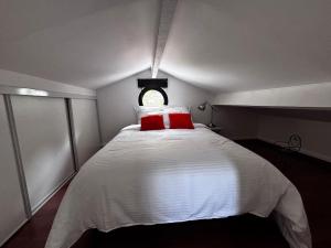 een slaapkamer met een wit bed en een rood kussen bij Maison V in Ventabren