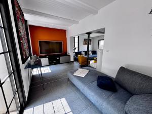 een woonkamer met een bank en een flatscreen-tv bij Maison V in Ventabren