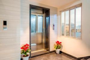 a elevator in a building with two potted plants at Hotel Helixo Classic Kompally in Hyderabad +20 photos