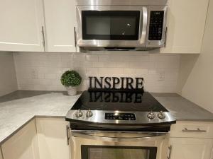 een keuken met een fornuis en een magnetron bij Modern, Cheerful 2 Bdrm Ohana Vacation Cottage in Kelowna