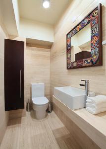 Mackenzie Beachfront Suite في Scala: حمام مزود بمرحاض ومغسلة ومرآة