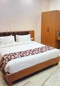 a bedroom with a large bed with a wooden cabinet at Shree Radha inn in Ayodhya