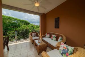 a balcony with wicker furniture and a large window at Veranda 4B - 3bdr 3bath in Isla Herradura