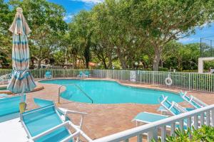 a swimming pool with chairs and an umbrella at Ocean Oaks PHB-8 in Cape Canaveral