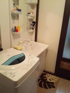 a bathroom with a white sink and a mirror at 京樽3号 1棟貸切 一軒家 3-Bedrooms Duplex Private Villa KYOTARU3 in Otaru