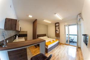 a room with a bed and a kitchen with a sink at NAR Royalton Suite #65 in Niš