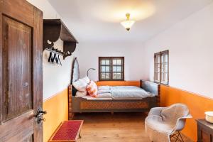 ein Schlafzimmer mit einem Bett und einem Stuhl darin in der Unterkunft Augenweide in Bad Feilnbach