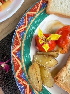 a plate of food with bread and tomatoes and toast at Villa Mangofera in Galle +26 photos