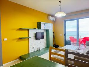 都拉斯Panoramic Sea View Stay Beachfront Center Location的客厅设有黄色墙壁和电视