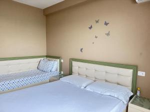 都拉斯Panoramic Sea View Stay Beachfront Center Location的墙上有蝴蝶的房间的两张床