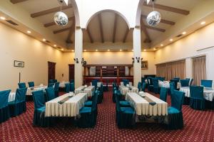 a banquet hall with blue and white tables and chairs at Sayohat Hotel in Tashkent