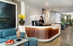 Eine Frau, die an einem Tresen in einer Lobby steht. in der Unterkunft Dusit Hotel Siem Reap in Siem Reap + 85 Fotos
