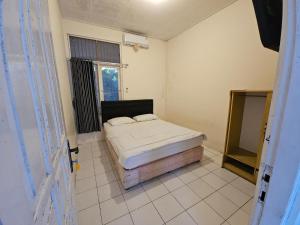 Una cama o camas en una habitación de Hotel Anugerah Wisata by Yurooms