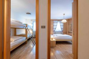 a room with two bunk beds and a hallway at Cesa Vivi in Canazei