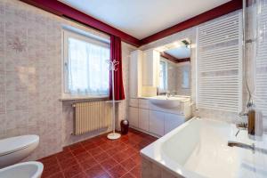 a bathroom with a tub and a toilet and a sink at Cesa Vivi in Canazei +13 photos