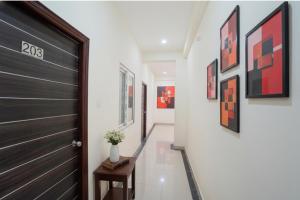 un pasillo con una puerta negra y pinturas en las paredes en FabHotel Paramhans Guest House - Sant Ravidas Ghat, en Varanasi