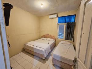 Una cama o camas en una habitación de Hotel Anugerah Wisata by Yurooms 3 fotos más