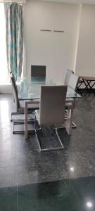 einem Glastisch mit Stühlen und einem Laptop darauf in der Unterkunft 7Hills Residency in Anantapur