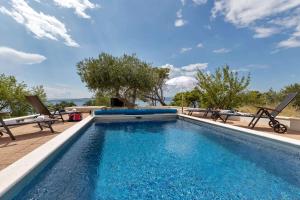 Holiday Home Berulia في بريلا: حمام سباحة مع كرسيين وطاولة