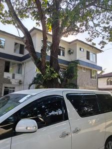 een wit busje geparkeerd voor een huis bij Huasheng Hotel in Dar es Salaam +18 foto's