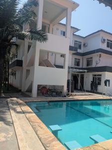 een huis met een zwembad ervoor bij Huasheng Hotel in Dar es Salaam