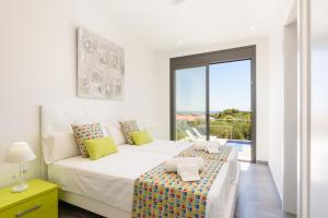 a white bedroom with a large bed and a window at Villa Dolce Vita by Escape Home in Son Bou +38 photos