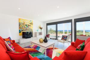 a living room with a red couch and a table at Villa Dolce Vita in Son Bou