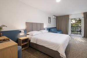 a bedroom with a large bed and a balcony at Alemaris Resort in Baška Voda