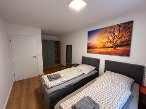 zwei Betten in einem Zimmer mit einem Gemälde an der Wand in der Unterkunft Klein Höpper in Albertshofen