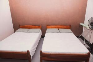 two twin beds in a room with a wall at Firenze in Hikkaduwa