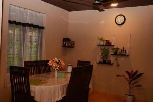 a dining room table with chairs and a clock on the wall at Firenze in Hikkaduwa +11 photos