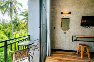 a room with a balcony with a table and a mirror at Lanta Chaolay in Ko Lanta