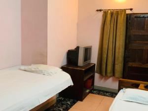 a bedroom with a bed and a tv on a table at JS Homestay in Nāgercoil