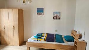 a bedroom with a bed and a wooden cabinet at Apartmenthaus-Winkler Wiener Neustadt Umgebung 