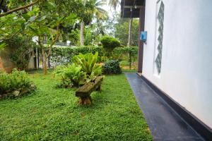 a wooden bench sitting in the grass next to a building at Firenze in Hikkaduwa