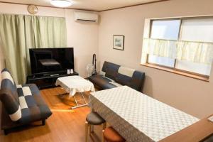 a living room with a couch and a table at Riverside Mizukiリバーサイドミズキ in Uruma +11 photos