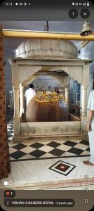 Zimmer mit einem Bett in einem Zimmer mit einem karierten Boden in der Unterkunft ganga kashi niwas in Varanasi + 1 Foto