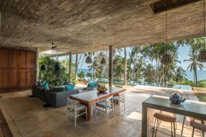 Una sala de estar abierta con una mesa y un sofá. en Walatta House, en Tangalle