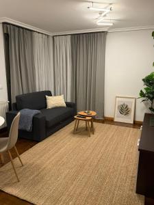 una sala de estar con un sofá y una mesa en El Pasaje Apartamento, en Oviedo