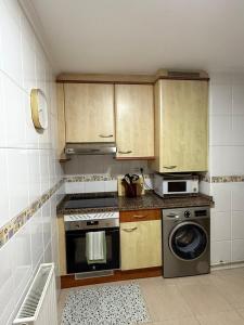 una pequeña cocina con fogones y lavavajillas en El Pasaje Apartamento, en Oviedo 13 fotos más