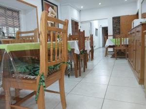 a dining room with wooden chairs and a table at Lily Guesthouse in Bloemfontein