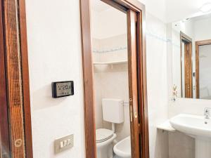 ein Badezimmer mit einem WC und einer Uhr an der Tür in der Unterkunft La Terrazza sul Bosco - Vista&Relax a Sestola in Sestola + 17 Fotos