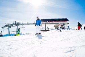 Eine Person steht auf Skiern im Schnee neben einem Skilift. in der Unterkunft La Terrazza sul Bosco - Vista&Relax a Sestola in Sestola