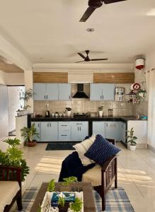 a kitchen with white cabinets and a couch in a room at The Little Idyll in Dharmsala