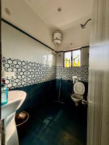 a bathroom with a toilet and a sink at The Little Idyll in Dharmsala