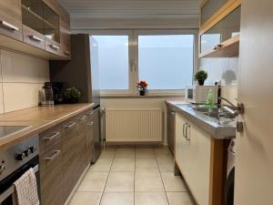 T&K Apartments - Comfortable 4 and 5 room Apartments - 20min Fair Messe CGN في أوفرات: مطبخ كبير مع خزائن خشبية ومغسلة +26 صورة