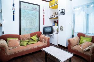 Del CarmenMangrove Breeze Country Inn by RedDoorz的有两张沙发和一台电视的客厅