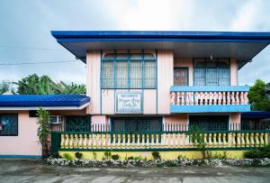 Del CarmenMangrove Breeze Country Inn by RedDoorz的蓝色屋顶的粉红色建筑